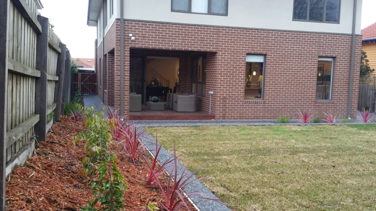 Modern backyard with patio furniture and landscaped garden.