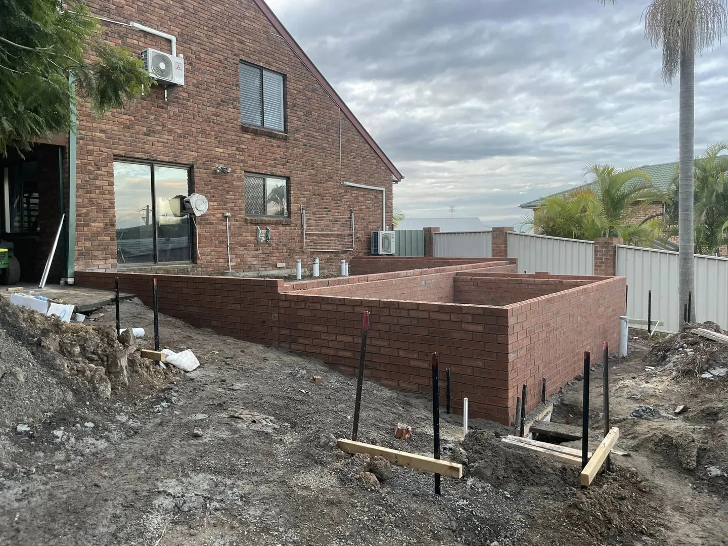 Backyard construction of new brick extension in progress.