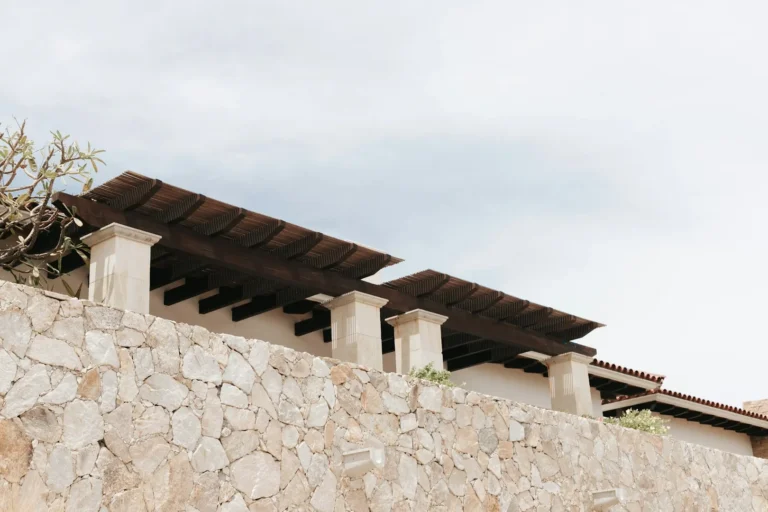 Stone wall with wooden roof structure above.