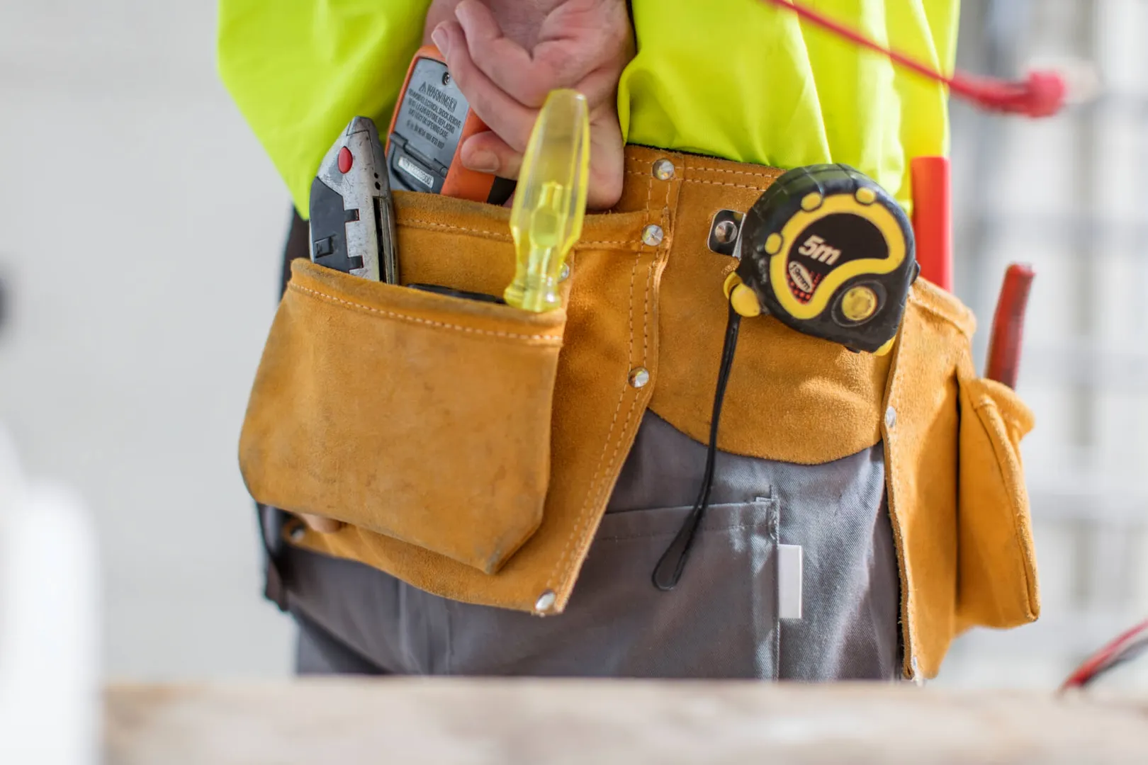 Construction worker's tool belt with essential tools.